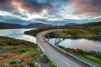 High angle view of road by mountains against sky