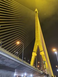 Low angle view of illuminated bridge against sky at night