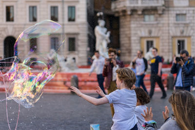 Children with bubble on street in city