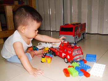 Boy playing with toys on floor at home