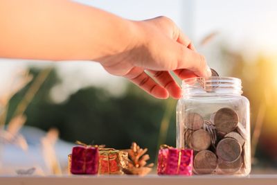 Close-up of hand holding ice cream in jar on table