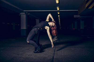 Portrait of woman posing in parking lot at night