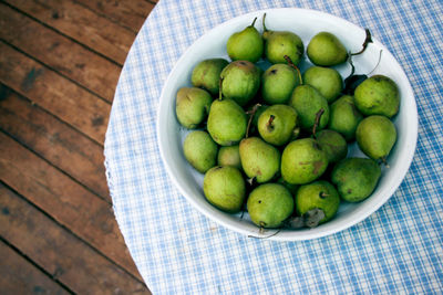 High angle view of pears in bowl on place mat