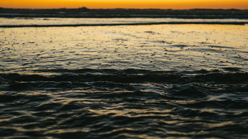 Close-up of sea against sky at sunset