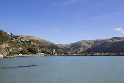 Scenic view of sea and mountains against blue sky