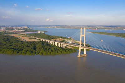 Bridge over river in city against sky