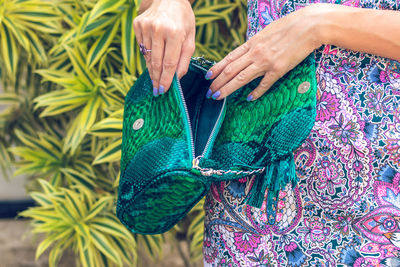 Midsection of woman holding leaf