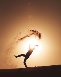 Silhouette man against sun during sunset