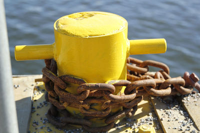 Close-up of bollard with rusty chain on dock