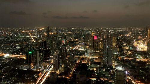 High angle view of illuminated cityscape against sky at night