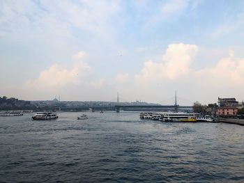 View of boats in sea against cloudy sky