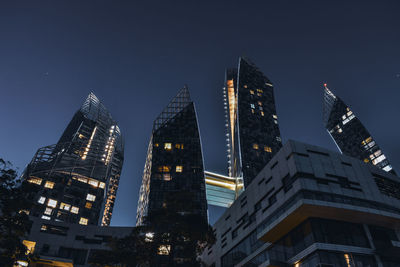 Low angle view of illuminated buildings against sky at night