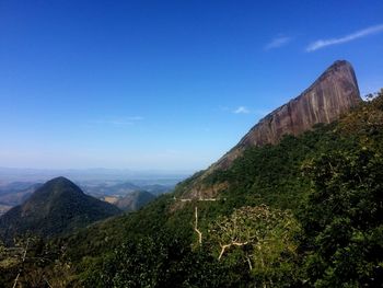 Scenic view of mountains against blue sky