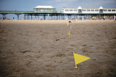 Yellow umbrella on beach against sky