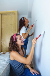 Woman standing against wall at home