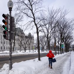 Woman in snow covered city against sky