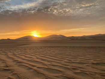 Scenic view of desert against sky during sunset