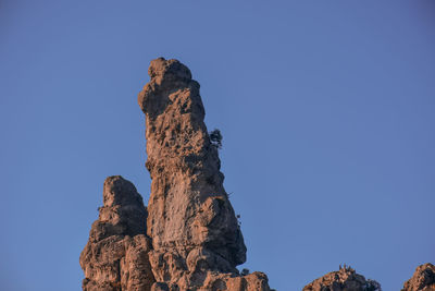 Low angle view of rock formation against blue sky