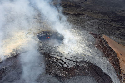 High angle view of smoke emitting from volcanic crater 