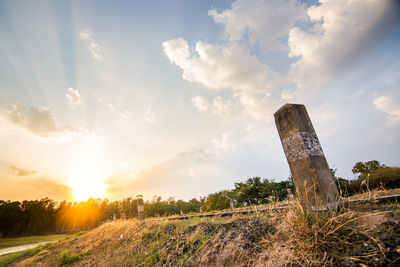 View of abandoned land on field against sky during sunset