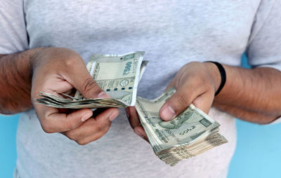 Midsection of man removing paper currency