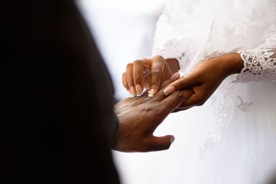 Cropped hand of couple exchanging wedding ring