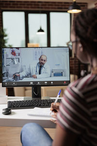 Midsection of woman using laptop on table