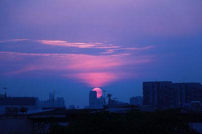 Silhouette buildings against sky at sunset