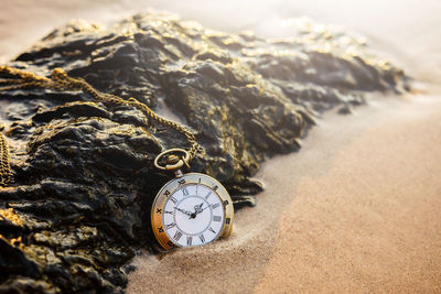 Close-up of clock on sand
