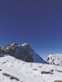 Scenic view of snowcapped mountains against clear blue sky