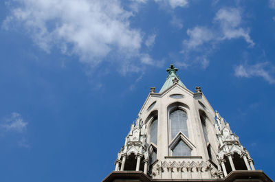 Low angle view of bell tower against blue sky