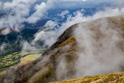 Scenic view of foggy mountain against sky