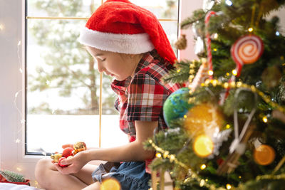 Rear view of woman holding christmas tree