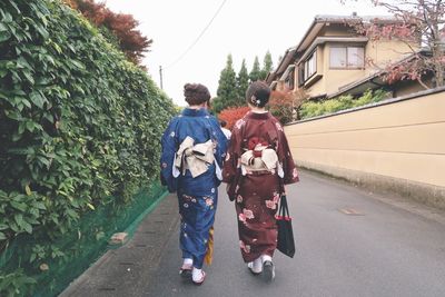 Rear view of friends walking on street