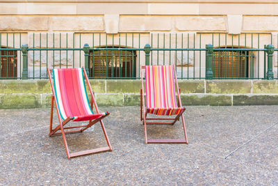 Empty chairs against the wall of a building