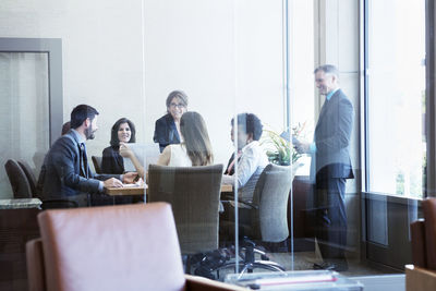 Businesswoman showing document to colleagues in board room during meeting