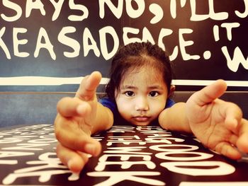 Portrait of cute girl sitting on table