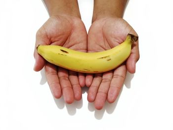 Midsection of person holding fruit against white background