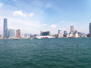 Sea by buildings against sky in city