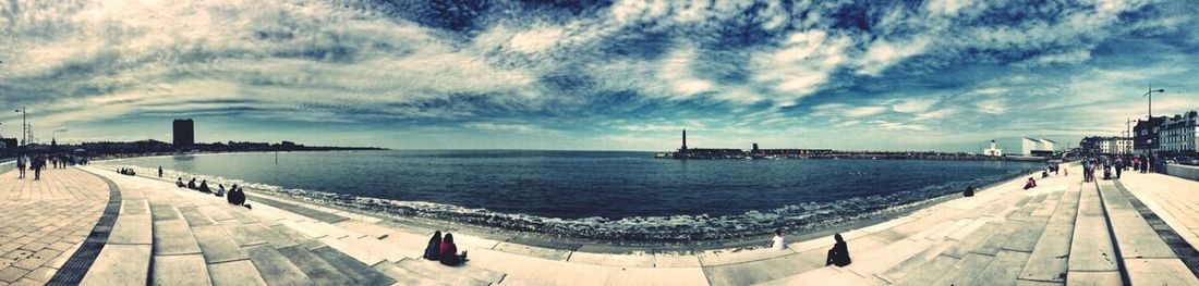 Pier on sea against cloudy sky