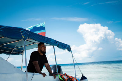 Man on boat at sea against sky