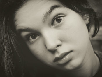 Close-up portrait of girl with raised eyebrows outdoors