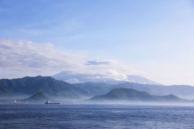 Scenic view of sea and mountains against sky