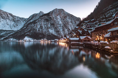 Scenic view of lake by snowcapped mountains against sky