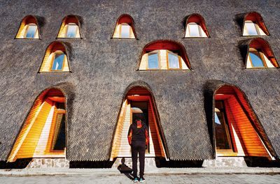 Full length rear view of man standing against traditional building