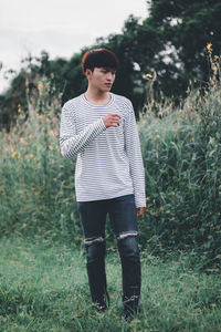 Full length of young man standing on field