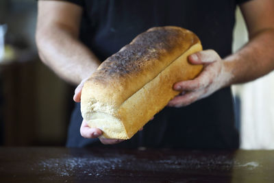 Midsection of man holding bread