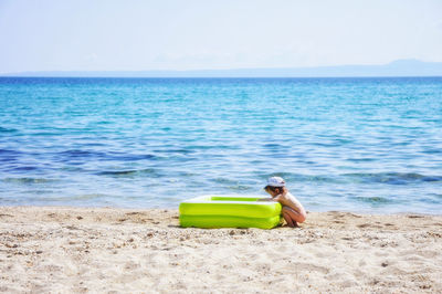 View of boy on beach against clear sky