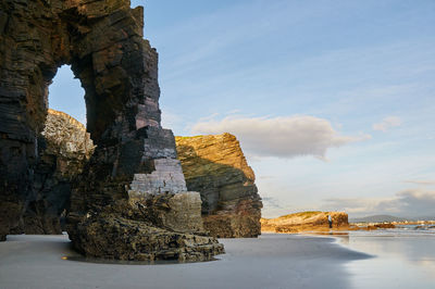 Built structure on rock with sea in background