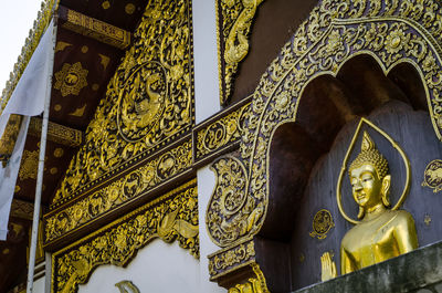 Low angle view of statue against temple building